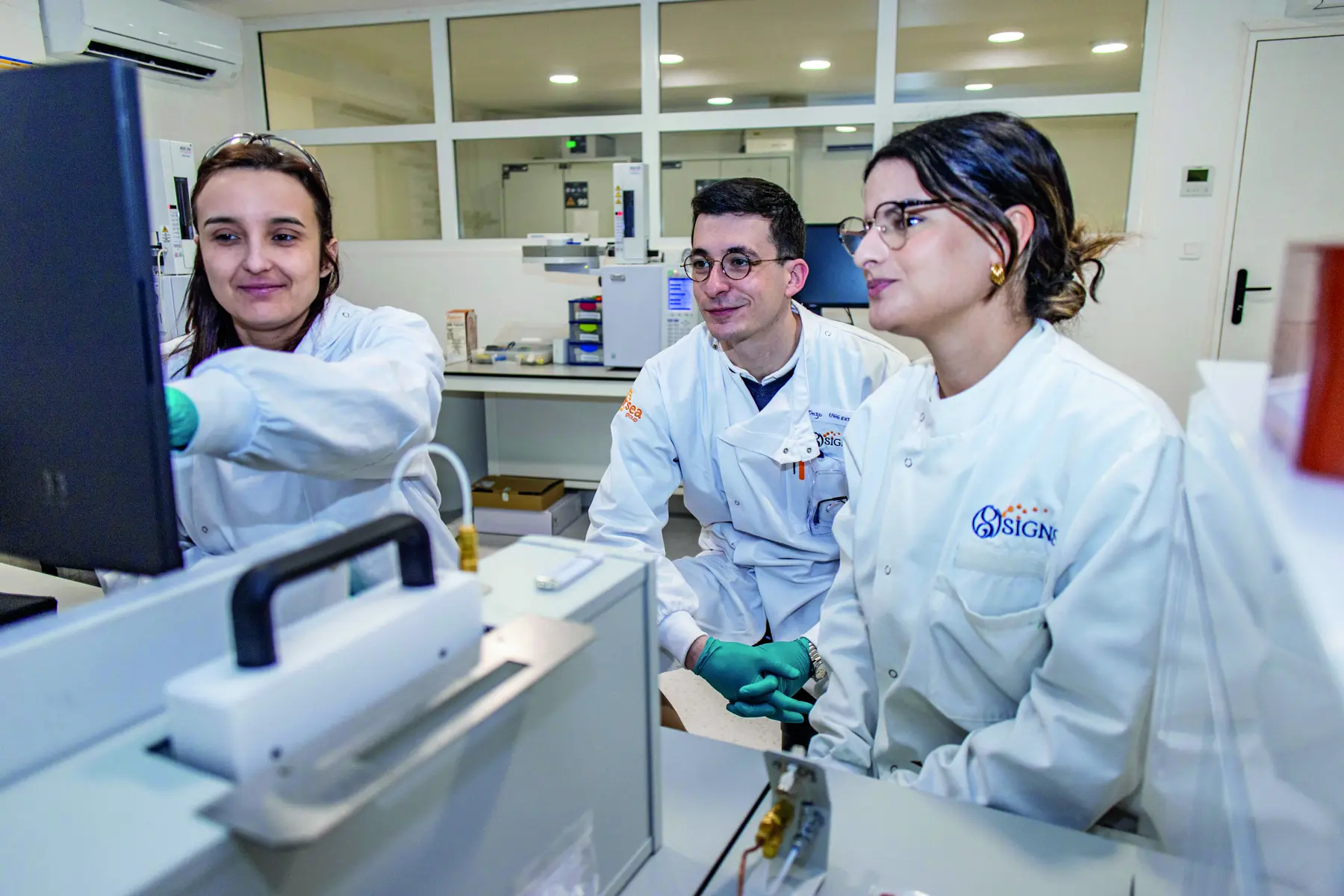 Trois membres de l’équipe SIGNS Labs au travail dans le laboratoire